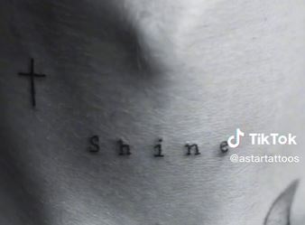 White has the word 'Shine' written on his neck next to a cross