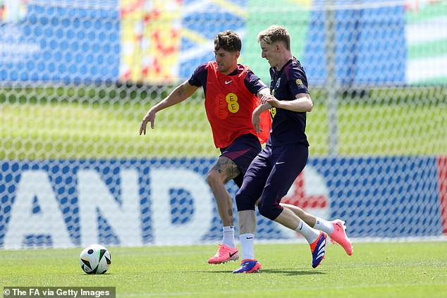 Anthony Gordon (right) is seen closing down John Stones during the England training session