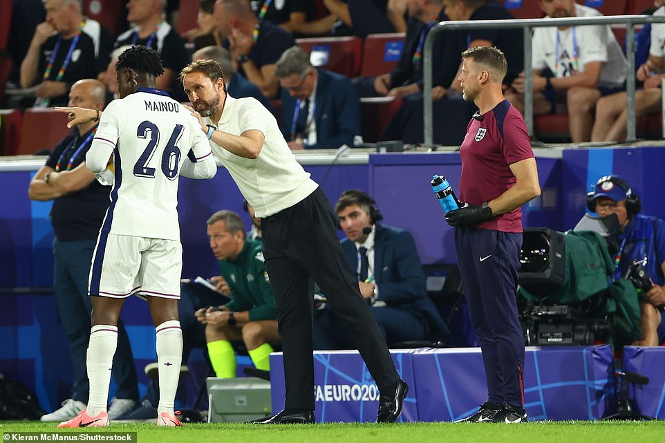 Gareth Southgate talks with Kobbie Mainoo of England during tonight's match against Slovenia